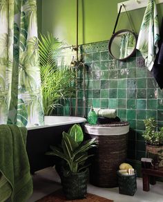 a bathroom with green tiles and plants in the tub, shower curtain, and rug