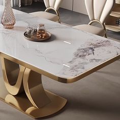 a marble dining table with gold legs in a modern living room setting by a fireplace