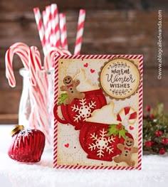 a christmas card with candy canes and gingerbread candies next to it on a table