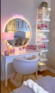 a white desk topped with a mirror next to a bed