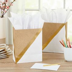 two brown and white paper bags sitting on top of a wooden table