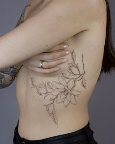 a woman with tattoos on her stomach and back is holding her arm over her shoulder