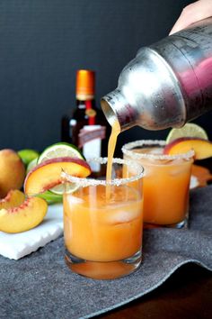 someone pouring orange juice into two glasses filled with peaches