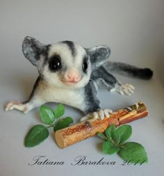 a small stuffed animal sitting on top of a table next to a piece of wood