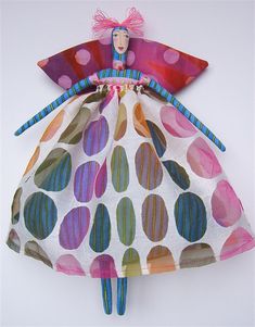 the doll is wearing a colorful dress with polka dots