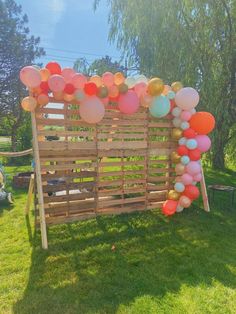 a wooden fence with balloons attached to it