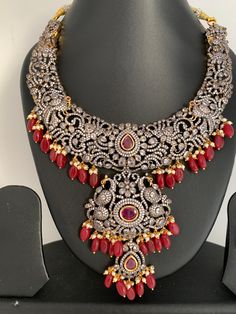 AD Red Stone Red Beads Dual Polish Neckline Necklace with Matching Screwback EarringsColor : Victorian and GoldenSize : Earring Length : 2 inches;Stones : AD Red Stone Pearls Red Beads