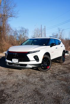 a white car parked on top of a dirt field