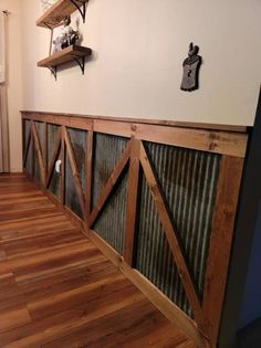 a room with wooden flooring and metal partitions on the wall next to it