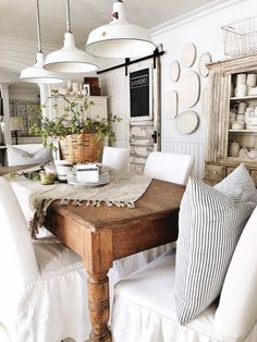 a wooden table topped with lots of white chairs