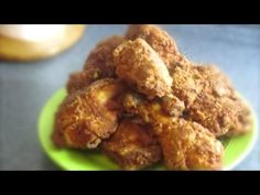 a green plate topped with fried food on top of a table