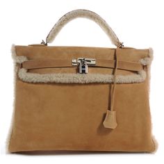 This is an authentic HERMES Veau Doblis Suede Shearling Teddy Plush Kelly 40 in Chestnut. This iconic Kelly handbag is uniquely designed of cuddly shearling and suede in a warm Chestnut color. Structured in the traditional Kelly shape, this rare handbag features palladium silver hardware at the straps and feet and includes a suede shoulder strap. The top flap opens to a suede and leather interior with a zippered pocket. Brighten up a cold day with this stunning masterpiece, by Hermes! Rare Handbags, Chestnut Color, Leather Interior, Cold Day, Silver Hardware, Chestnut, Shoulder Strap, Top Handle Bag, Handbags