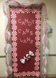 a door decorated with candy canes and white tulle for the front entrance to a school