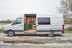 a white van parked in a parking lot with its doors open and the door ajar