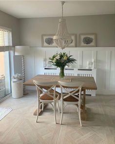 a dining room table with two chairs and a chandelier