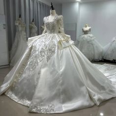 wedding gowns are displayed on mannequins in a room with white walls