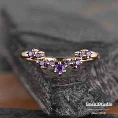 three amethyst purple stones are placed on top of each other in this gold ring