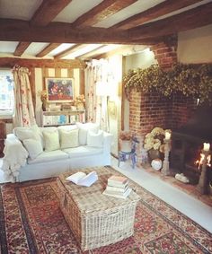 a living room filled with furniture and a fire place next to a brick wall in front of a fireplace