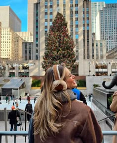 two women standing in front of a christmas tree with an elephant on it's head