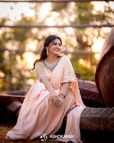 a woman sitting on the ground in a pink dress