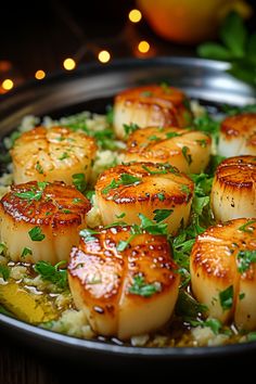 seared scallops on top of rice in a skillet with garnishes