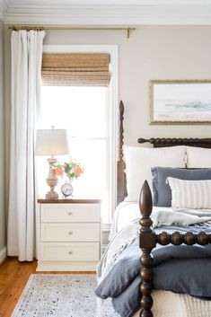 a bedroom with a bed, dresser and window