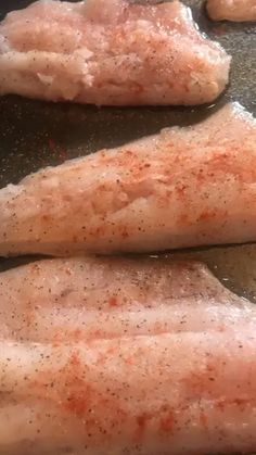 three pieces of chicken cooking in a frying pan with seasonings on them,