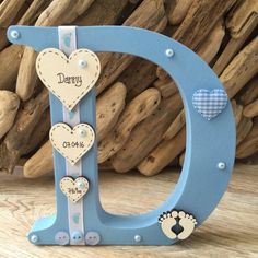 a blue wooden letter with hearts on it