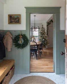 Green mudroom leading to a grey kit hen with wainscoting decorated for Christmas. Kitchen With Wainscotting Paint Colors, Kitchens With Wainscoting, Green Wainscoting Kitchen, Kitchen With Wainscotting, Green Wainscotting, Mudroom Wainscoting, Christmas Mudroom, Country Mudroom, Green Mudroom