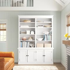 a living room filled with furniture and a fire place next to a wall mounted bookcase