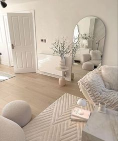 a living room filled with furniture next to a white door and mirror on the wall