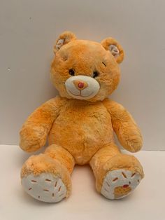 a brown teddy bear sitting on top of a white table