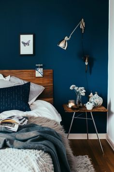 a bedroom with blue walls and white bedding