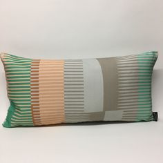 a decorative pillow with multicolored stripes on it's back and sides, sitting against a white background