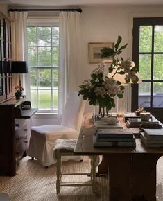 a living room filled with lots of furniture and flowers on top of a wooden table