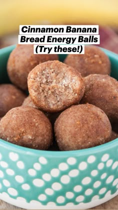 a blue bowl filled with chocolate covered donuts on top of a wooden table next to a banana