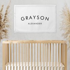 a baby crib in front of a sign that says grayson