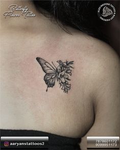 a woman's chest with a butterfly tattoo on her left shoulder and flowers in the middle