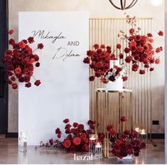 a wedding cake with red flowers and candles