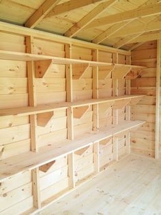 empty wooden shelves in an unfinished room with wood flooring and walls made out of plywood planks