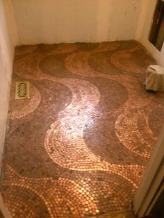 the bathroom floor is covered in penny tiles and has a toilet paper dispenser next to it