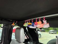 the interior of a car with several colorful items hanging from it's roof rack