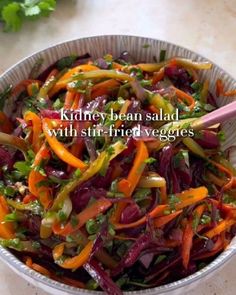 a bowl filled with mixed vegetables on top of a table