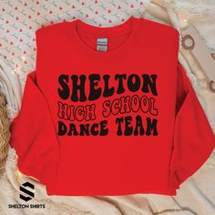 a red sweatshirt with the words sheilaton high school dance team on it next to some scissors