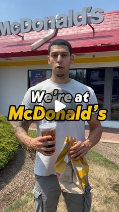 a man standing in front of a mcdonald's holding a drink