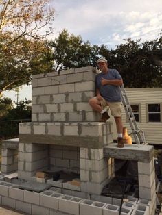 a man that is standing on top of a brick structure with a ladder in front of him