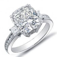 a cushion cut diamond engagement ring with channeled diamonds on the band and sidestones