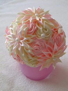 a pink vase filled with flowers sitting on top of a white tablecloth covered floor