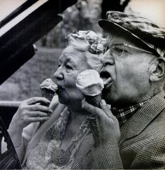 an old man and woman eating ice cream while sitting in a convertible car with the caption, forever young at heart