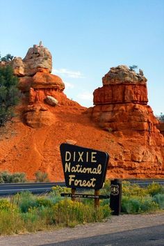 a sign for dixie national forest in front of some red rocks